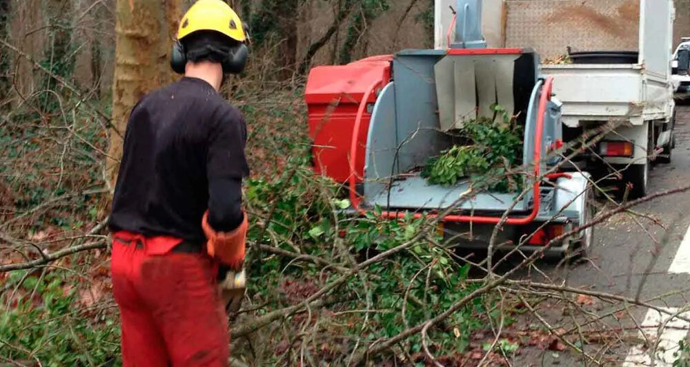 Broyage de branches avec un broyeur rouge et un camion